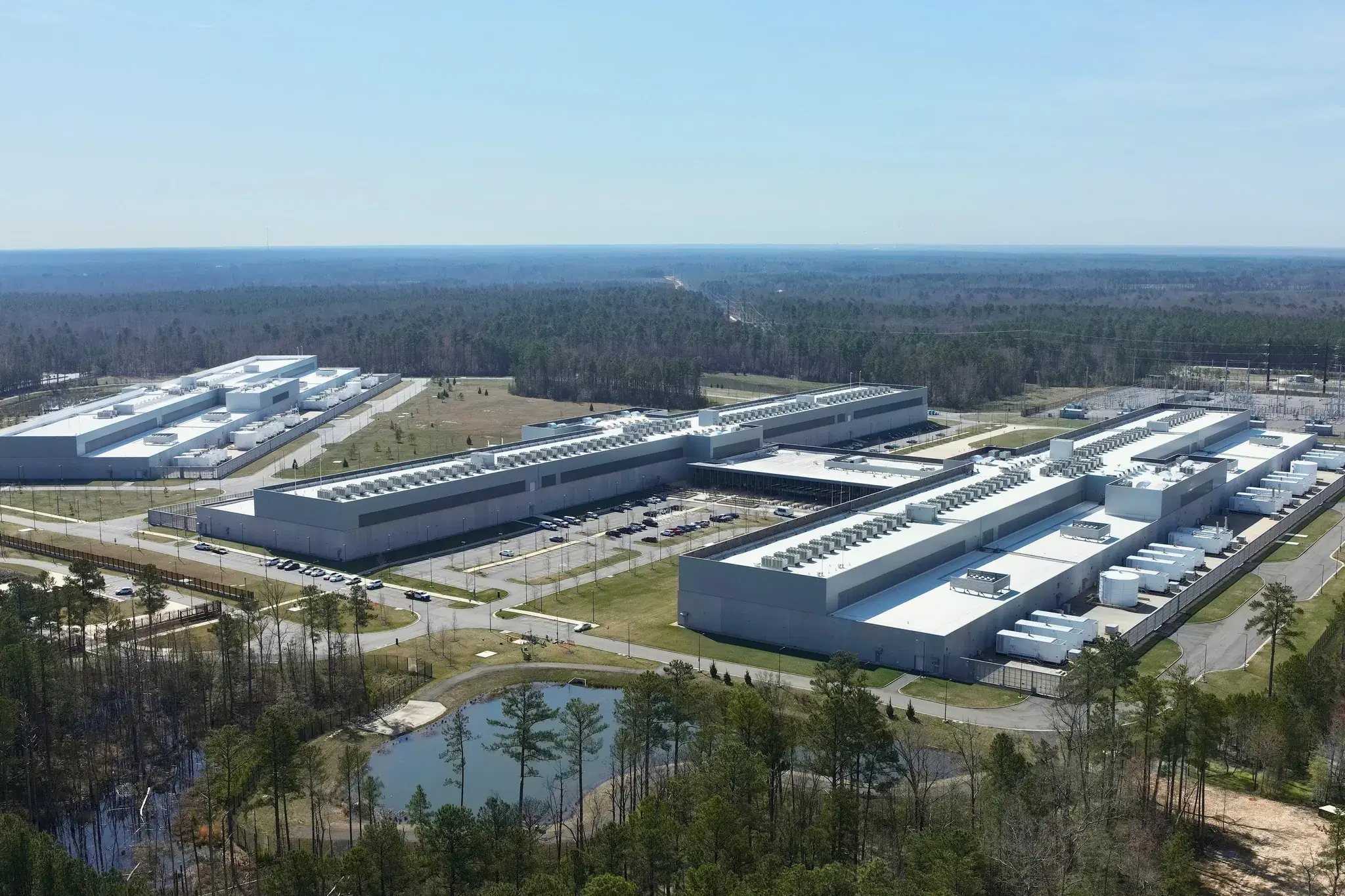 Aerial view of a data center campus with its substation, surrounded by forest