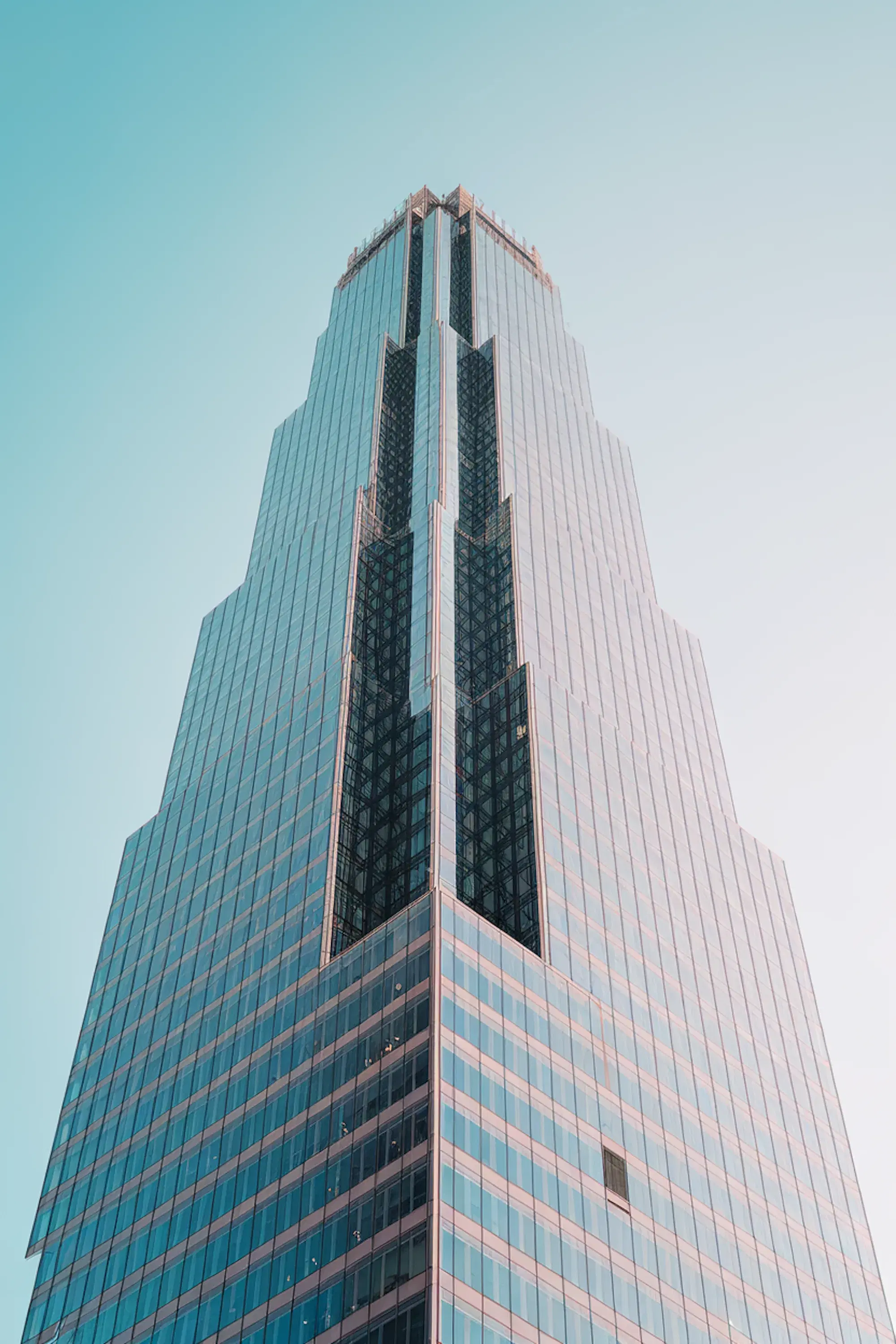 Glass office tower rising into a clear blue sky